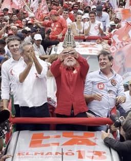 Lula ergue imagem de Nossa Senhora um dia após Flávio fazer o gesto: 'Vai ser a padroeira enquanto eu for presidente'
