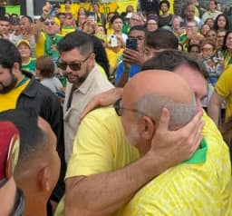 Pivô da rachadinha, Queiroz reaparece abraçado com Flávio Bolsonaro em Copacabana